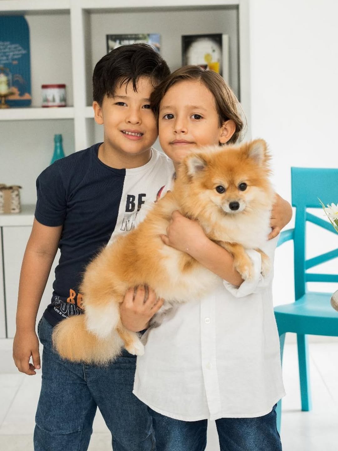 Dos niños abrazando un perro dentro del Café Restaurante Della Nonna en Bucaramanga.