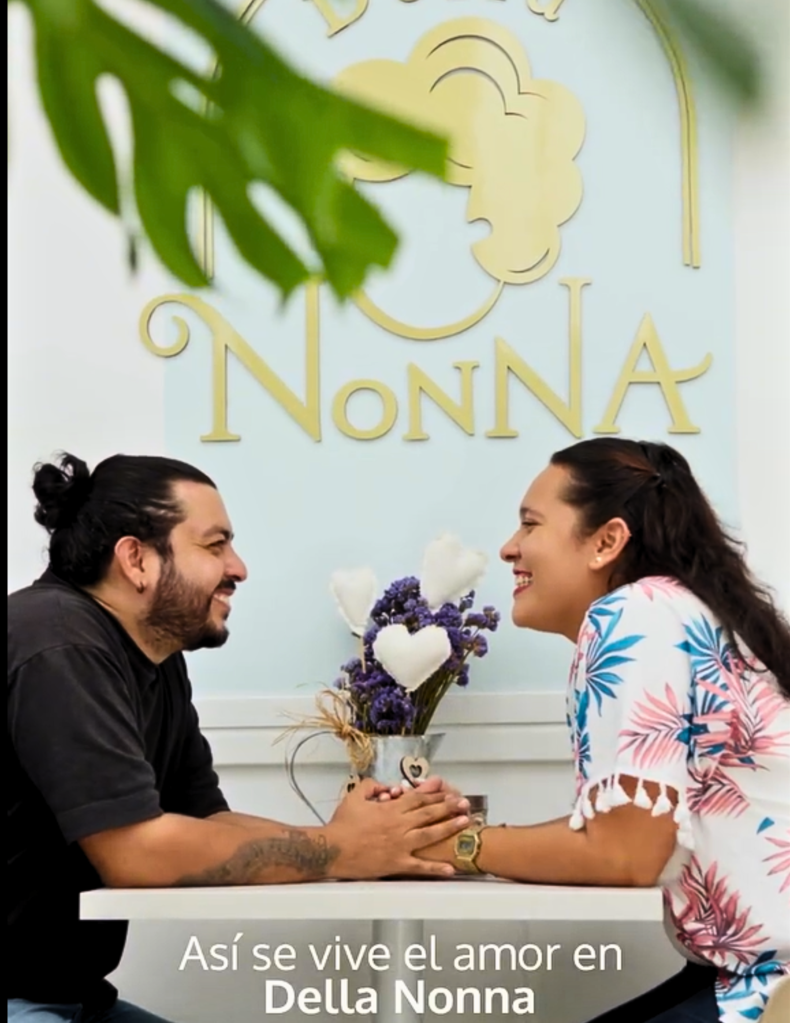 Pareja sonriendo y compartiendo en mesa dentro del Café Restaurante Della Nonna en Bucaramanga.